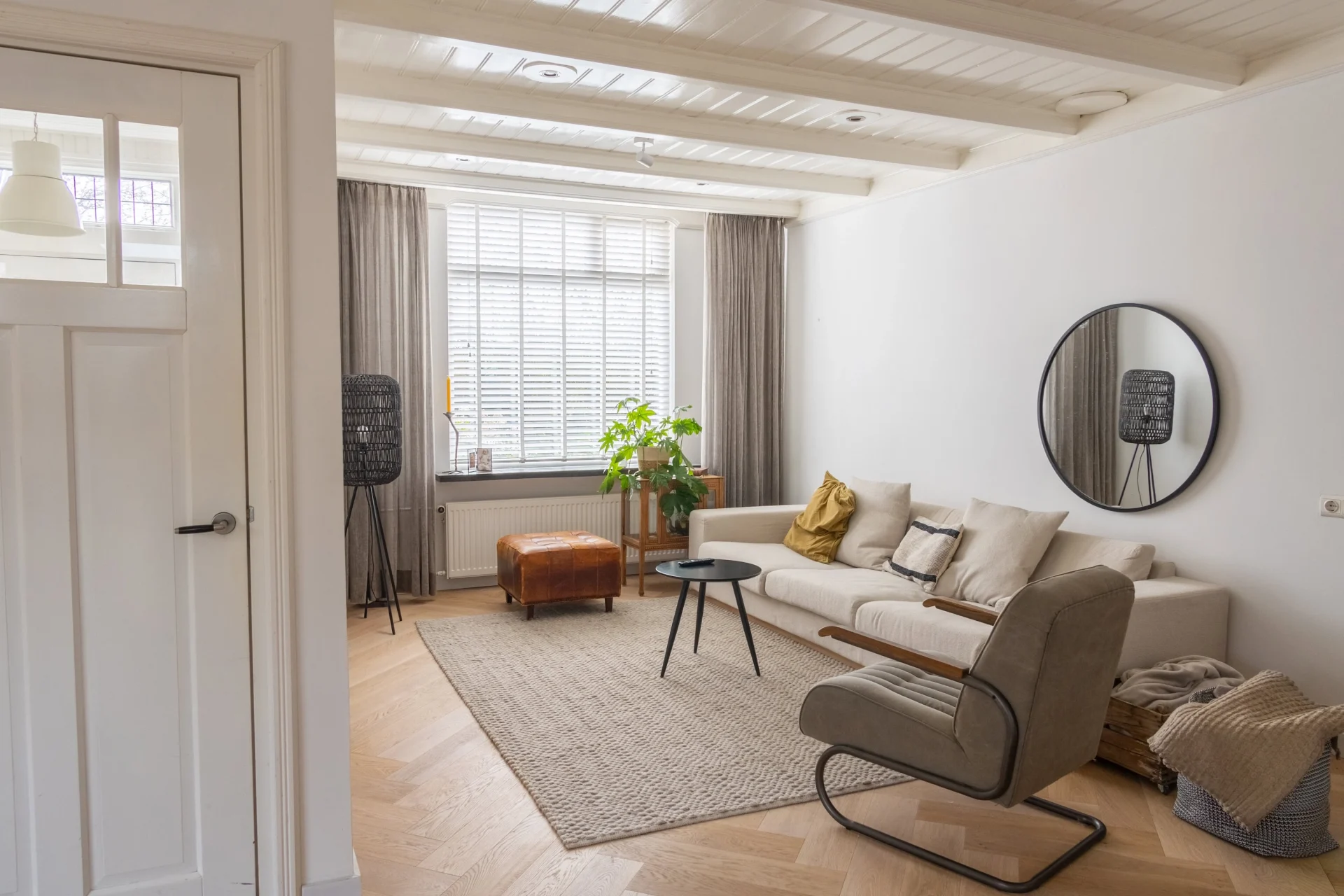 Gerenoveerde lichte woonkamer met houten vloer en grote ramen